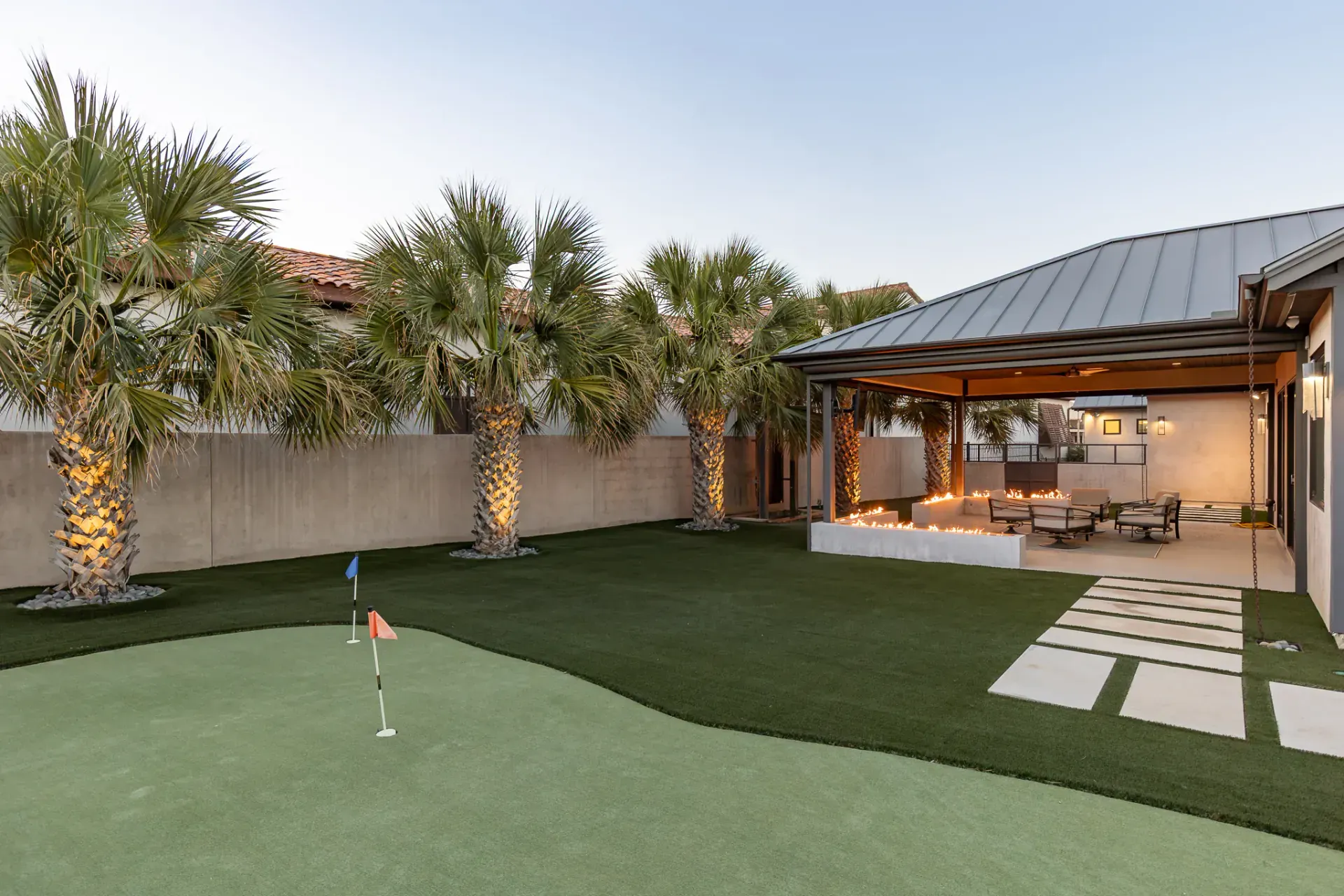 Private putting green at twilight with covered patio